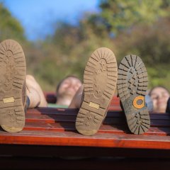 Zwei Wanderer ruhen sich auf einer Sinnesbank aus auf der Traumschleife Gräfin Loretta in Frauenberg. Man sieht die Schuhsohlen von unten.