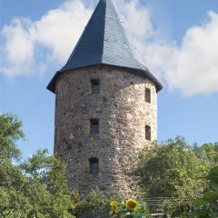 Dicker Turm  mit Blumenbeet