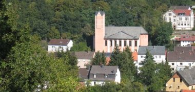 Die Kirche in Heimbach zwischen Wald und Häusern