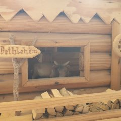 Kleines Holzschild vor eine Stall mit Ochsen. Bei der Krippenausstellung in Baumholder