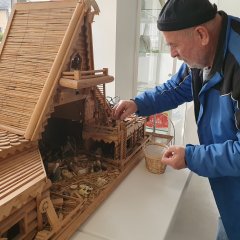 Günther Heinz räumt  Figuten in seine selbstgebaute Krippe ein bei der Krippenausstellung in Baumholder