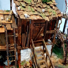 Krippe mit liebevoll gearbeiteten Details bei der Krippenausstellung in Baumholder. Holzschindeln, Leiter und Treppe aus Holz. Auf den Dachschindeln ist Moos aufgeklebt.