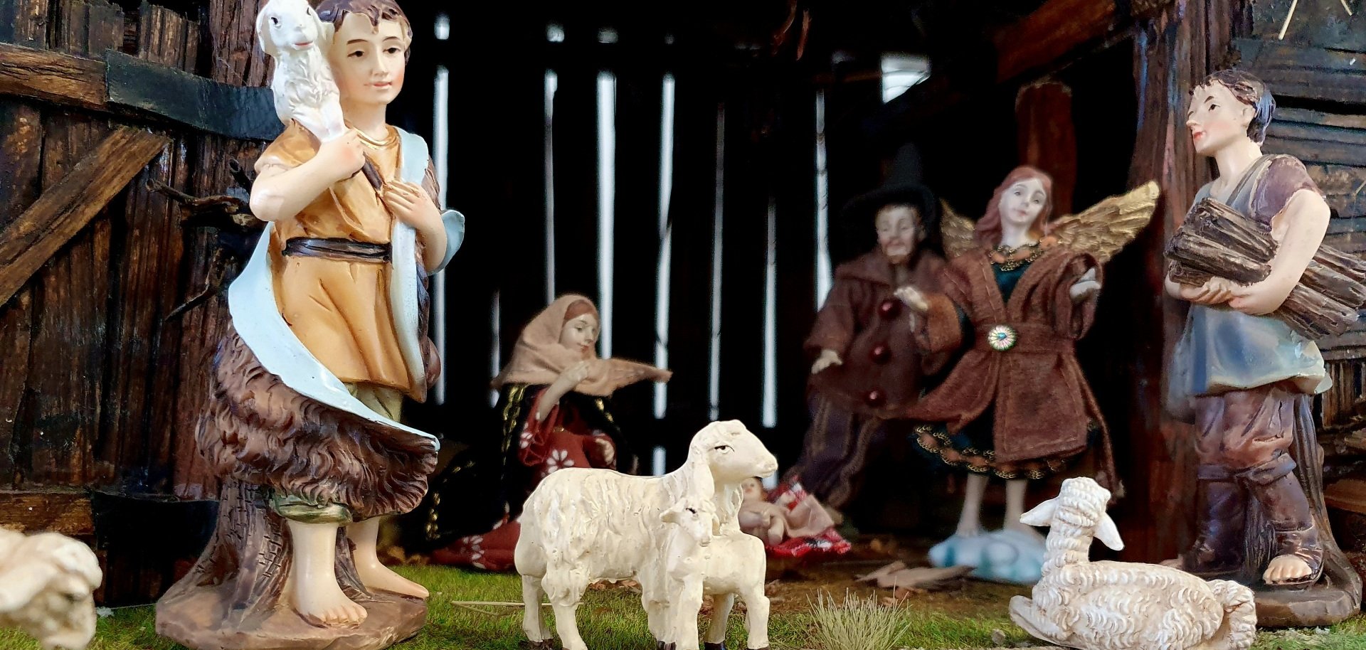 Szene in einer Krippe auf der Krippenausstellung in Baumholder. Maria, Josef und das Jesuskind im Stall. Davor Hirten mit Schafen und ein Engel.