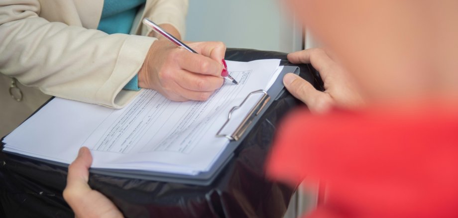Vorsicht walten lassen bei Verträgen an der Haustür. Eine Frau unterschreibt einen Vertrag
