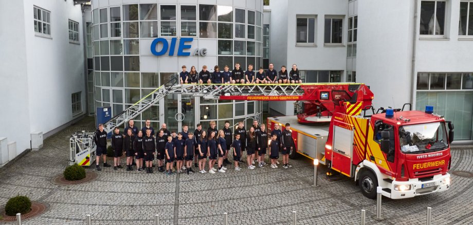 Die Jugendfeuerwehr ldar-Oberstein mit ihren neuen Teamoutfits Eine Gruppe von Jugendlichen neben einem Feuerwehrauto