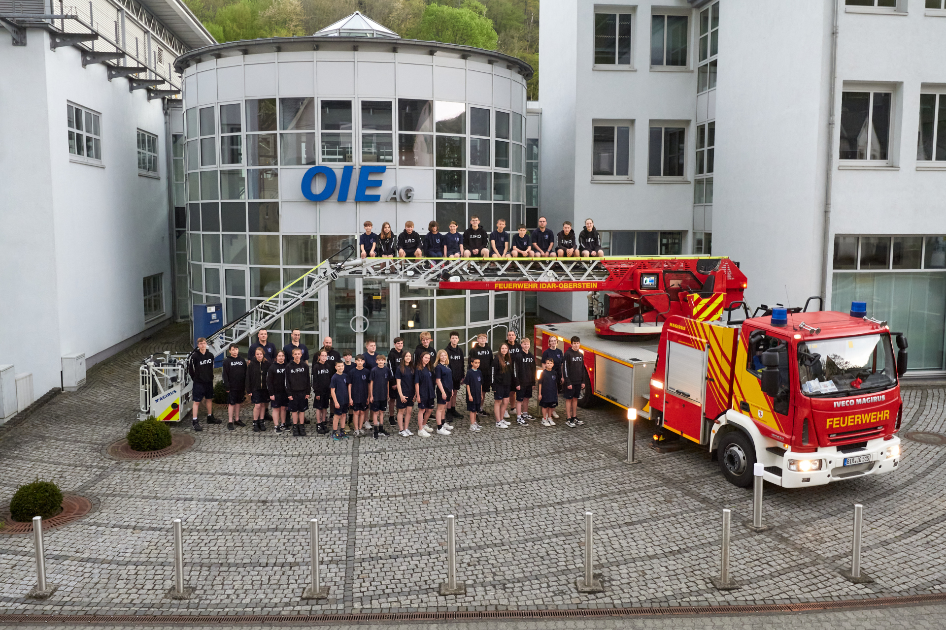 Eine Gruppe von Jugendlichen neben einem Feuerwehrauto