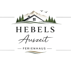 Ferienwohnung Hebels Auszeit in Heimbach - Logo. Ein Haus von dem nur das Dach herausschaut vor ien Berg über dem 2 Vögel fliegen. Rechts und links sind die Silhoutten von Tannen. Darunter der Schriftzug Hebels Auszeit - Ferienhaus -