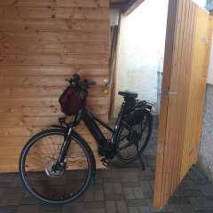 Ferienwohnung Eichner Baumholder - abschließbarer Fahrradabstellplatz. Fahrrad vor einem Holzschuppen mit Vorhängeschloß.