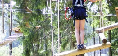 Kind in einem Hochseil Parcours