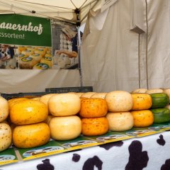 Gestapelte Käselaibe am Käsestand auf dem Bauernmarkt in Berglangenbach